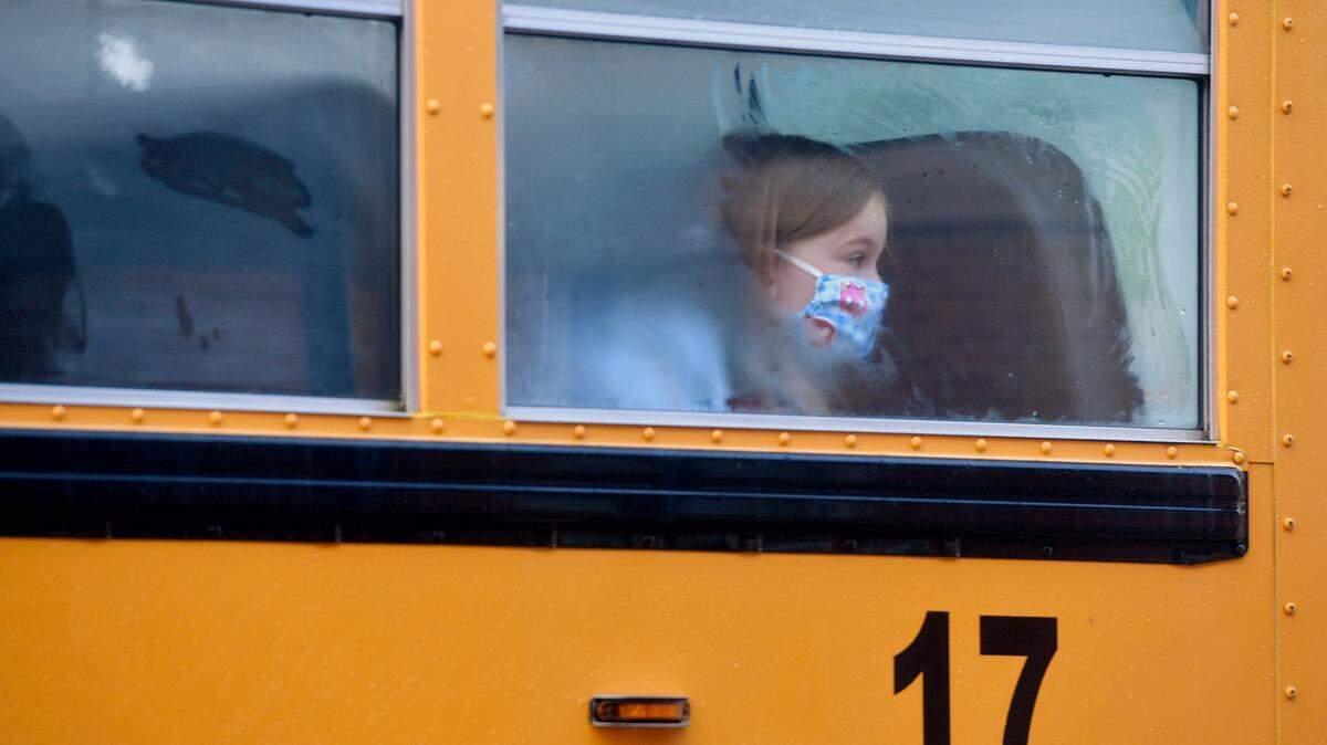 A student wearing a mask looks out the foggy window as the bus pulls up at Wingate Elementary for the first day on Tuesday, Aug. 25, 2020.