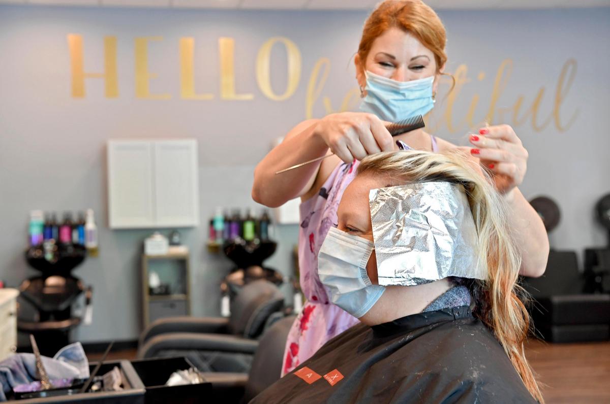 Liz Brown laughs with Tara Johns as she colors her hair at Salon Beautiful on Friday, May 29, 2020. It was the first day salons were allowed to reopen since March and the coronavirus pandemic shut down businesses.
