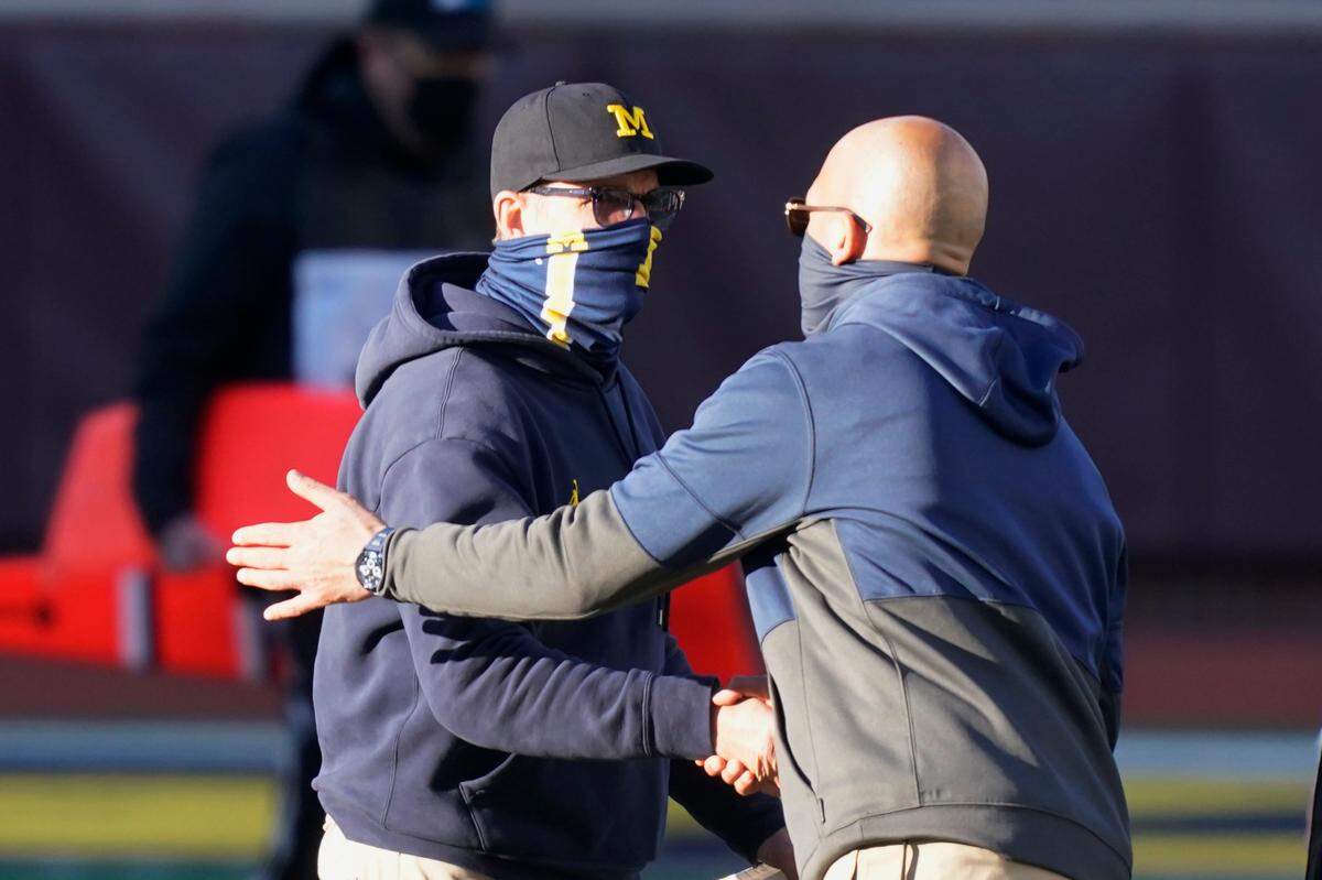 Michigan head coach Jim Harbaugh, left, greets Penn State head coach James Franklin after an NCAA college football game, Saturday, Nov. 28, 2020, in Ann Arbor, Mich. Penn State won 27-17.