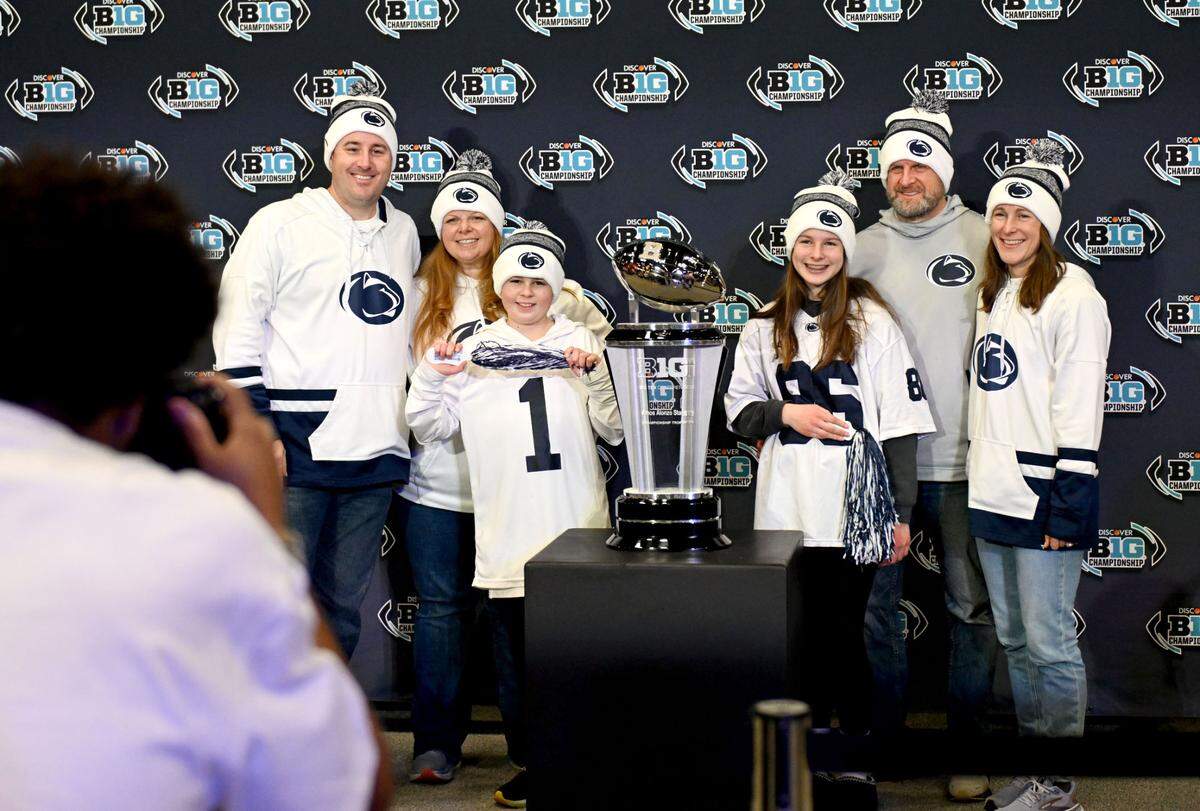 The Kadish and Donnelly family pose with the Big Ten Championship trophy at the Fan Fest sponsored by Dr Pepper at the Indianapolis Convention Center before the game on Saturday, Dec. 7, 2024.