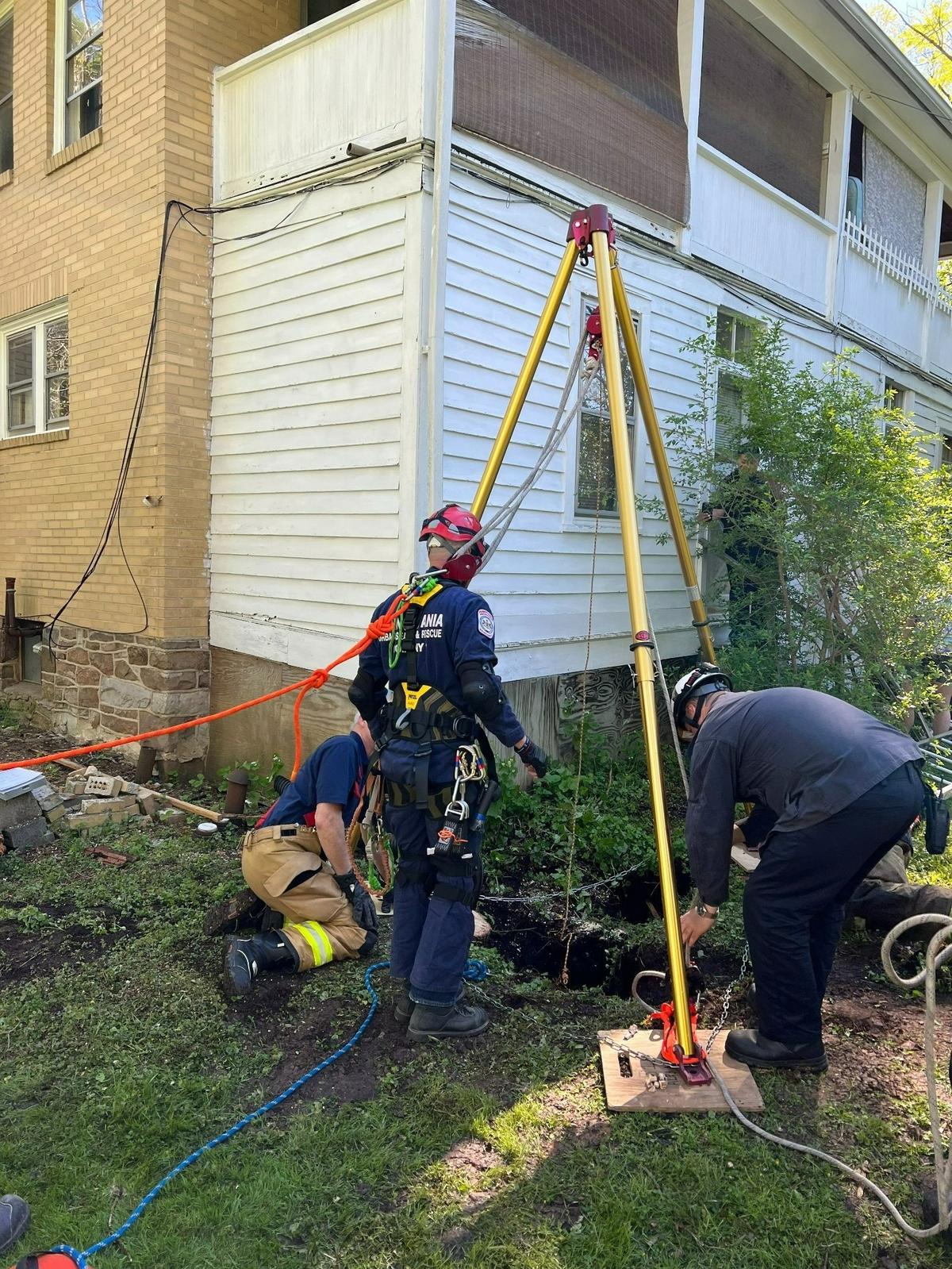 Alpha Fire Company firefighters work to rescue a corgi who fell into a sinkhole in College Township on Wednesday, May 11, 2022.
