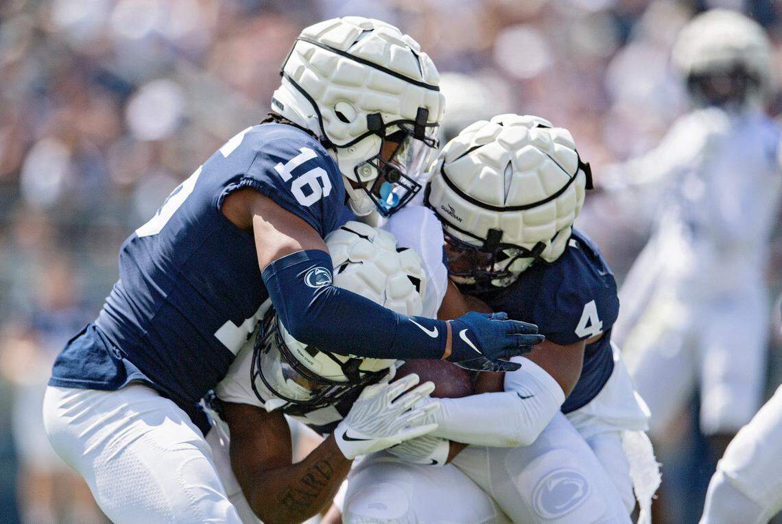 Penn State safety Ji’Ayir Brown and cornerback Kalen King stop the ball carrier during the Blue-White game on Saturday, April 23, 2022.