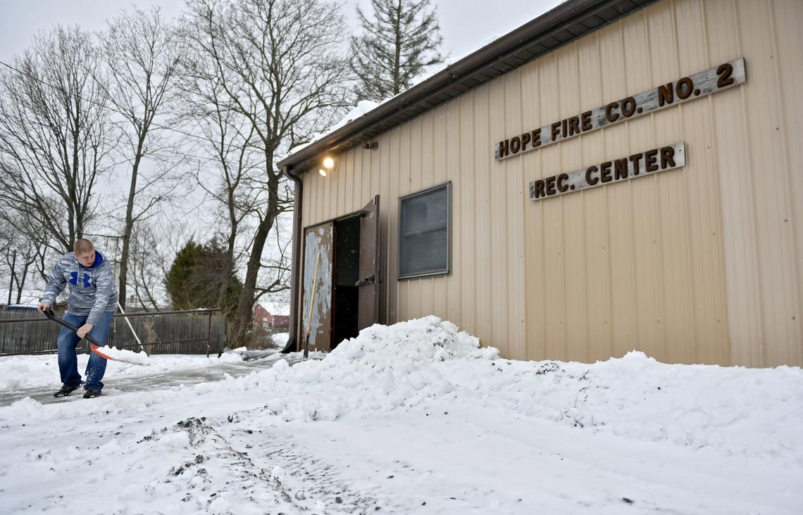 Justin Butterworth shovels the snow in front of the Hope Fire Company Recreation Center on Feb. 12. Volunteers from the company recently put in their time to renovate the center in hopes that it will bring more people to rent the space to help them raise funds.
