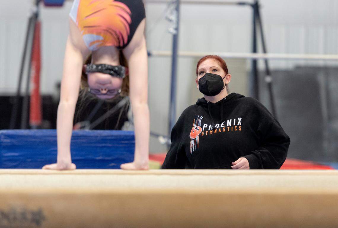 Coach Finda Reichert watches gymnast Kirra on the balance beam during practice at the Phoenix Academy of Performing Arts of Pennsylvania on Dec. 7.