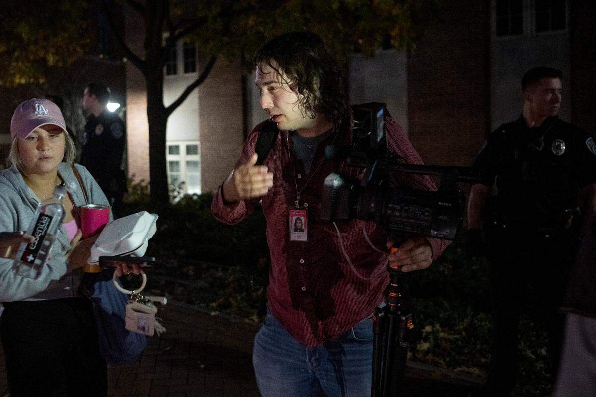 People try to wash their eyes after being hit with a bear deterrent spray outside of the Thomas Building on Monday, Oct. 24, 2022.