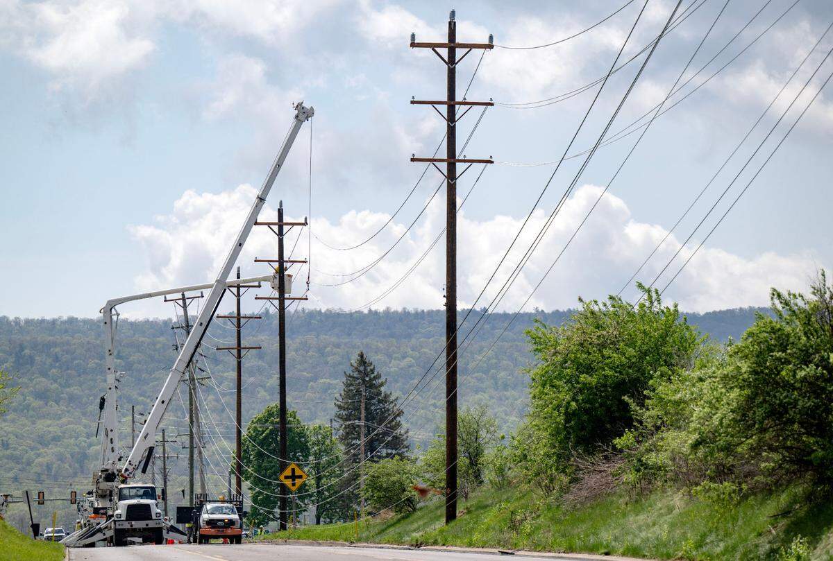 Utility workers replace and fix the poles and lines that came down along West College Avenue on Friday, May 2, 2025. Multiple poles came down when a derecho hit the area on Tuesday.