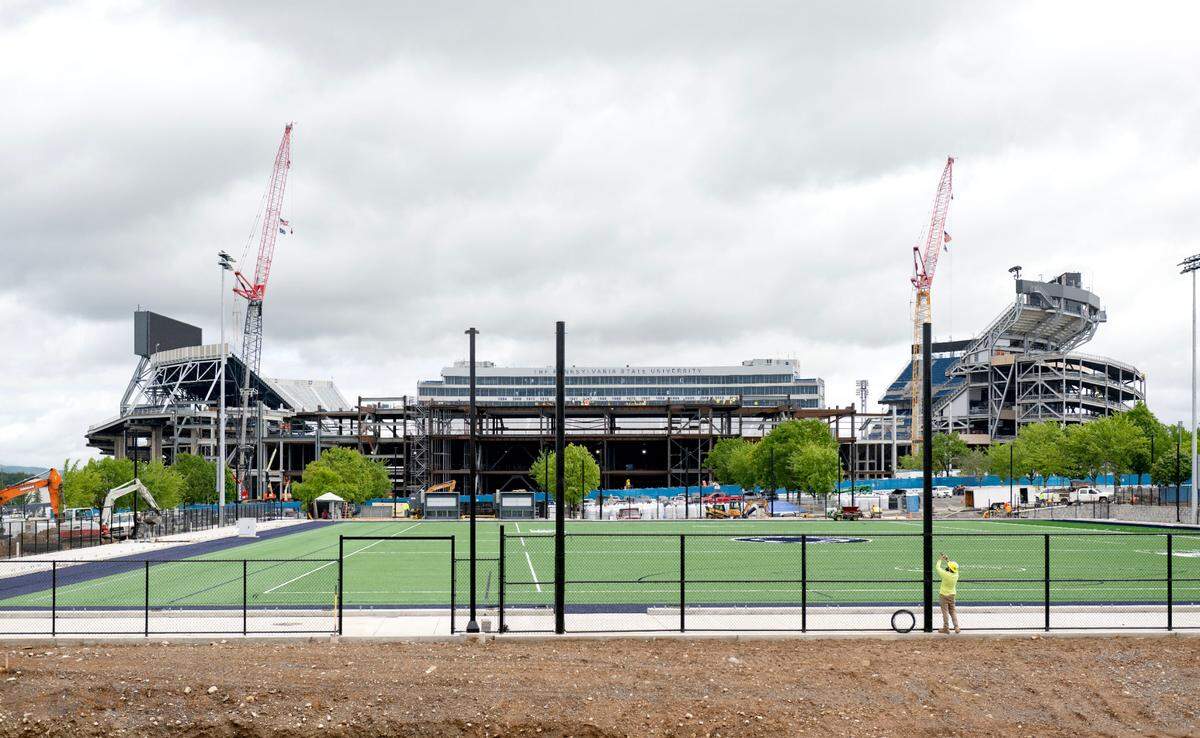Turf has been laid as construction of Penn State soccer’s indoor practice air-supported structure continues on Thursday, May 29 with the Beaver Stadium project pictured behind it.