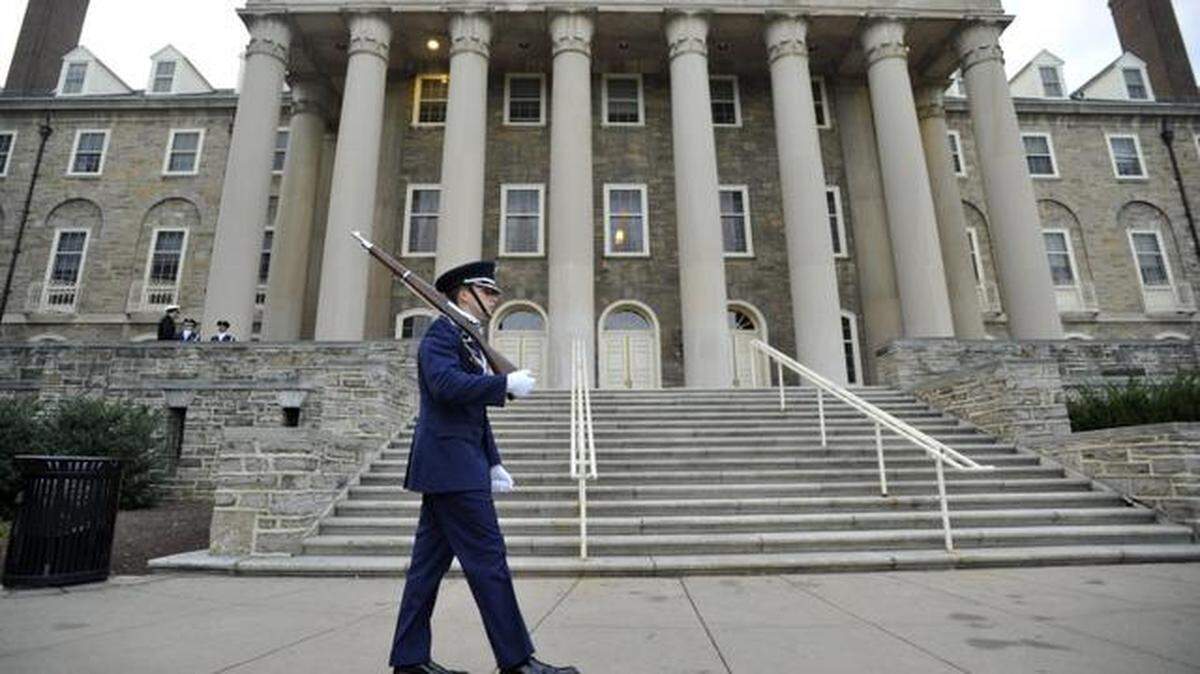 Kevin Tramaglini, an Air Force ROTC cadet, stands guard in front of Old Main at Penn State during a vigil in 2014. The university is by far the county’s top employer, providing more than 26,000 jobs.
