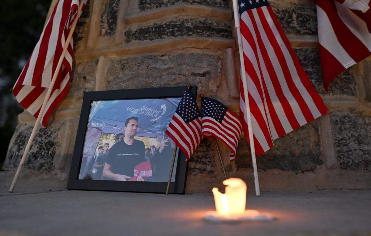 A photo from when Charlie Kirk visited the Penn State campus is surrounded by flags at a candlelight vigil hosted by the Penn State College Republicans and the Penn State chapter of Turning Point USA on Thursday, Sept. 11, 2025 on the Old Main lawn. 