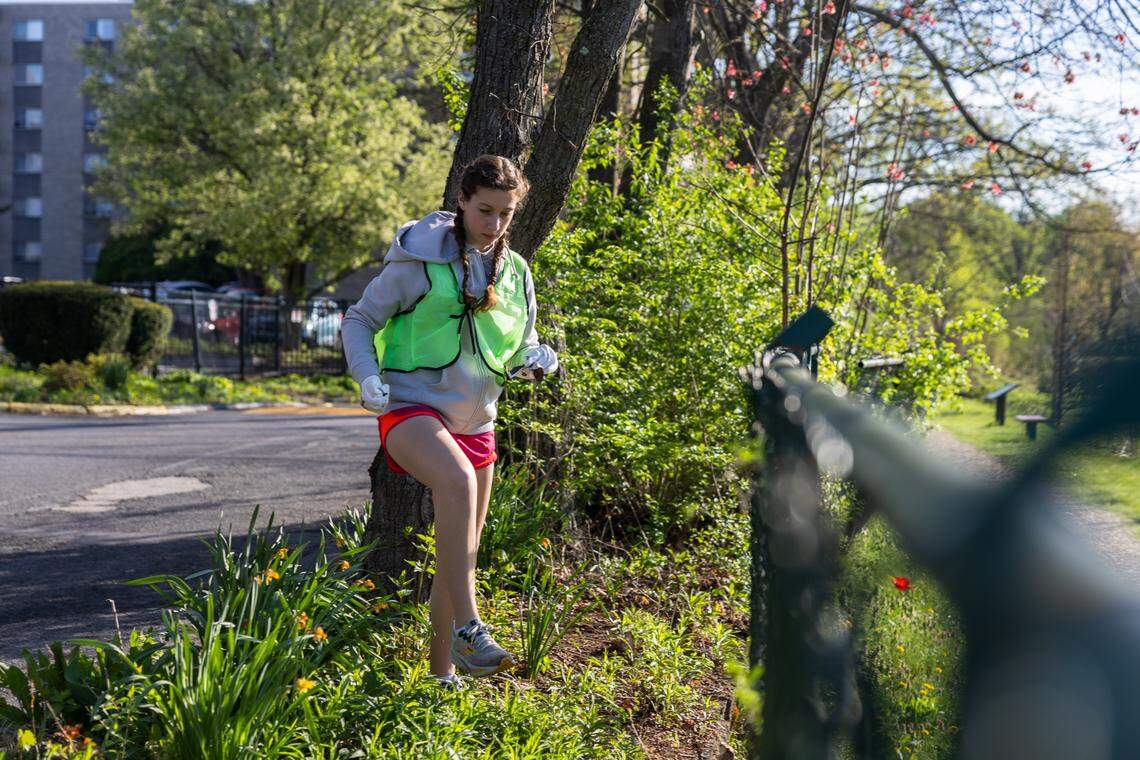 Lillian Belkin, a State High student, collects trash in a park off Westerly Parkway in State College, Pa., on Saturday, April 18, 2026. The ClearWater Conservancy organized volunteers across Centre County to clean up public green spaces.