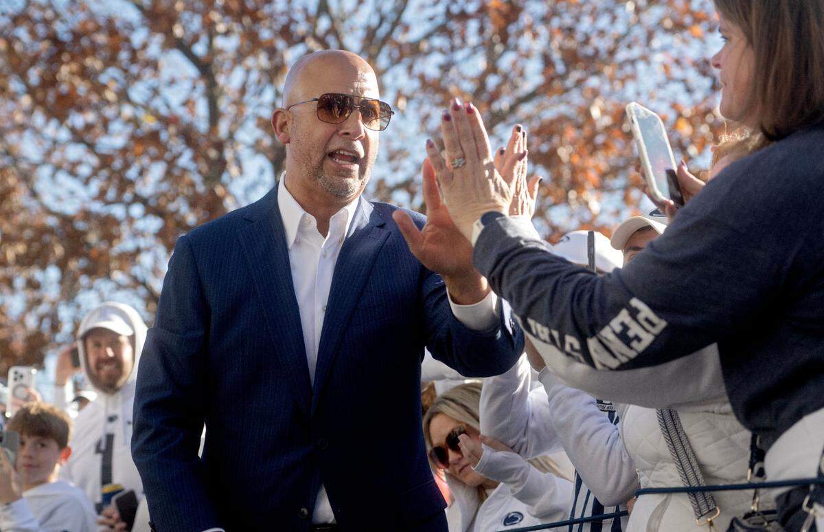 Penn State football coach James Franklin high-fives fans as he and the team arrive at Beaver Stadium for the game against Ohio State on Saturday, Nov. 2, 2024.