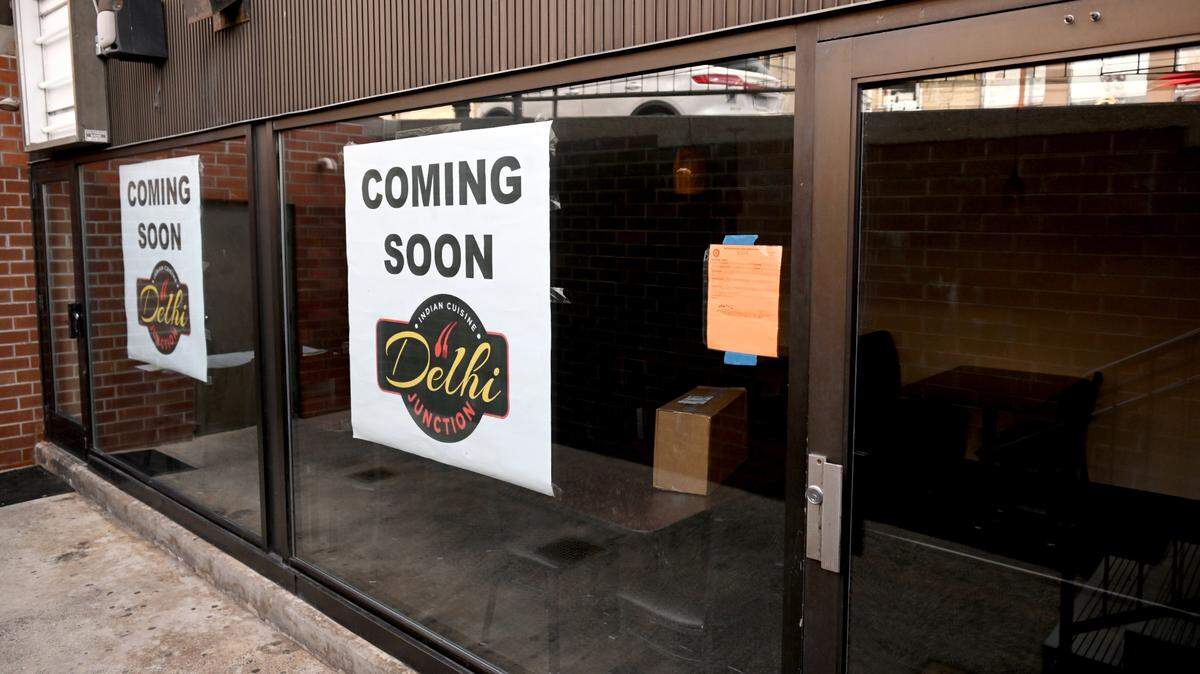 Signs promoting Delhi Junction hang at 128 Locust Lane, which is below College Mart on Thursday, March 14, 2024.