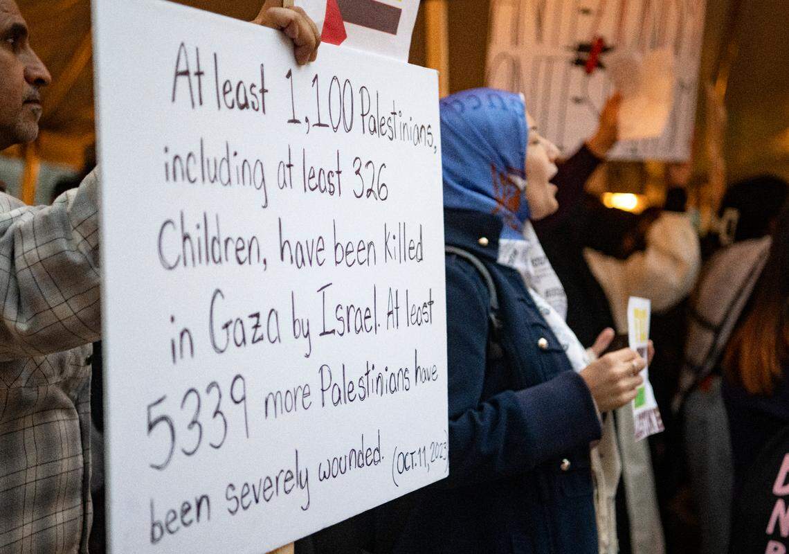 A man holds a sign about the amount of Palestinians killed in Gaza as people gather to show support for Palestine at the Allen Street gates on Thursday, Oct. 12, 2023.