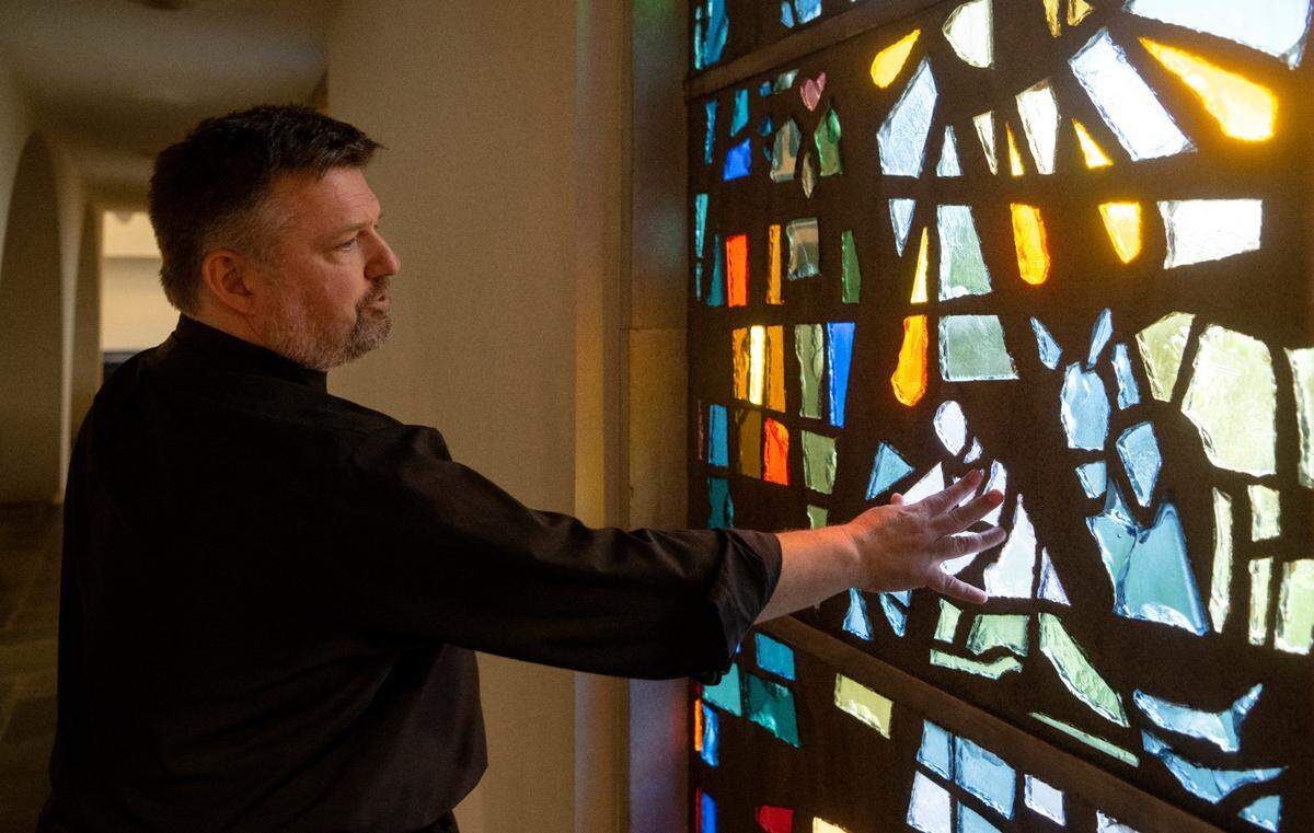 Senior Pastor Scott Schul talks about the imagery in the stain glass windows at Grace Lutheran Church on Wednesday, Aug. 30, 2023.
