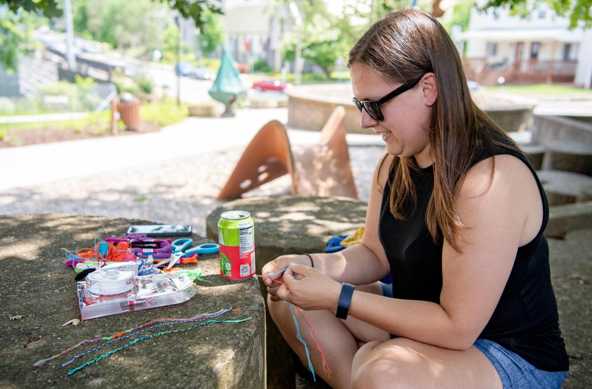 Monica Ochs works on friendship bracelets on Monday, June 22, 2020 in Sidney Friedman Park. Ochs has sent bracelets to Alaska and Texas to connect with family and friends as part of the Central Pennsylvania Festival of the Arts Tying Us Together campaign.