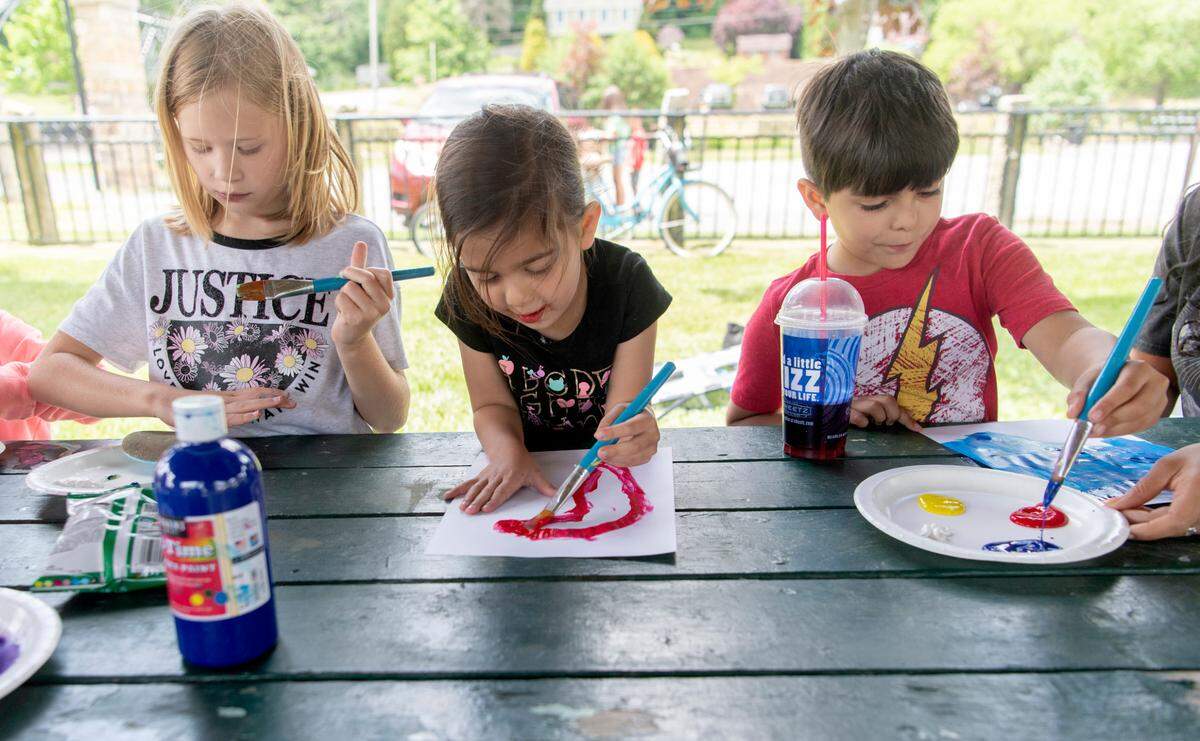 Youngsters paint rocks and pictures at the Free to Be Me Summer Tour event at the Cold Stream Dam on Friday, June 10, 2022.