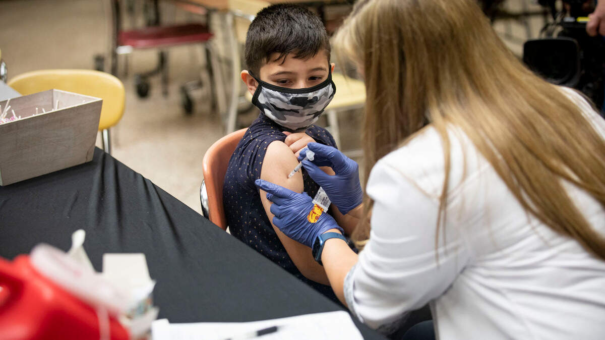 A child receives a vaccine from a nurse.