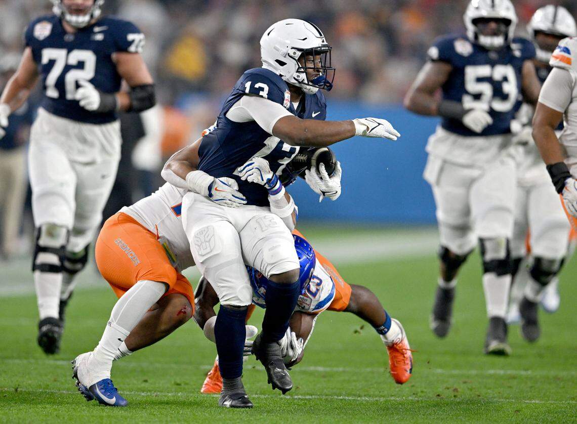 Boise State defenders try to pull down Penn State running back Kaytron Allen during the Fiesta Bowl on Tuesday, Dec. 31, 2024 at State Farm Stadium.