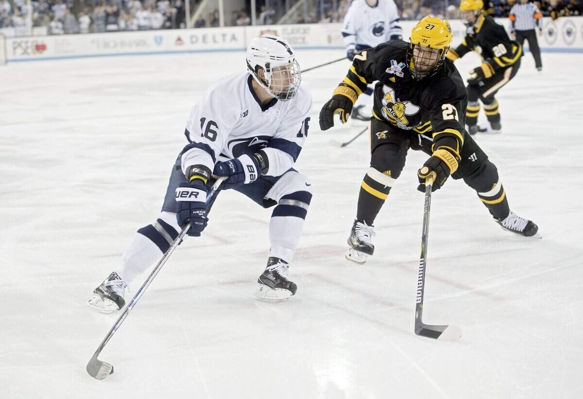 Penn State’s Andrew Sturtz skates around American International College’s Janis Jaks during the Thursday, October 19, 2017 game at Pegula Ice Arena.