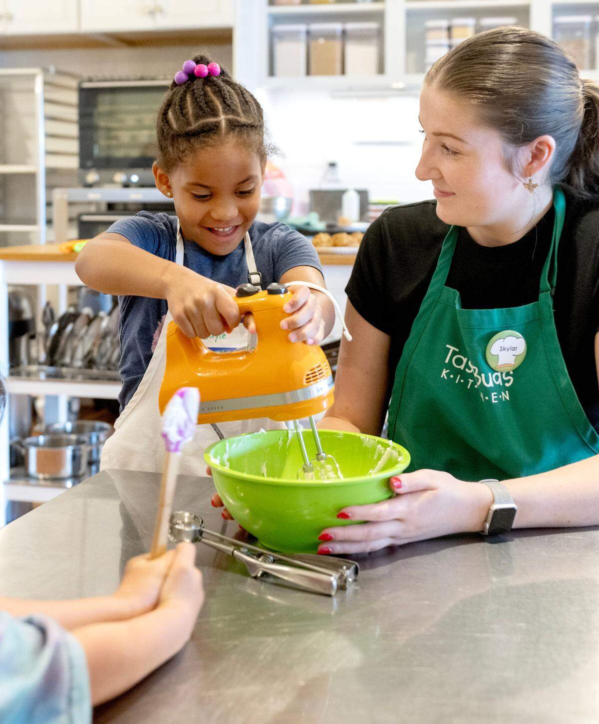 Instructor Skylar Shultz helps campers mix together the cream cheese filling for their apple oatmeal cream pies during Taste Buds Kitchen summer camp on Tuesday, July 1, 2025.