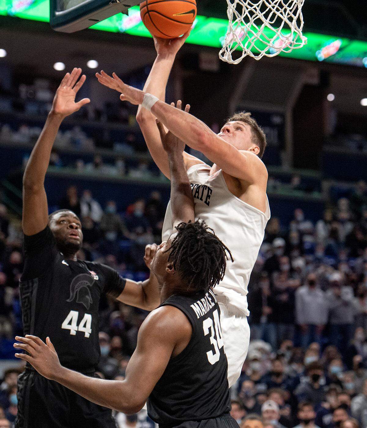 Michigan State’s Julius Marble II fouls Penn State’s John Harrar as he goes in for a basket with limited time left in the game on Tuesday, Feb. 15, 2022. Penn State won 62-58.