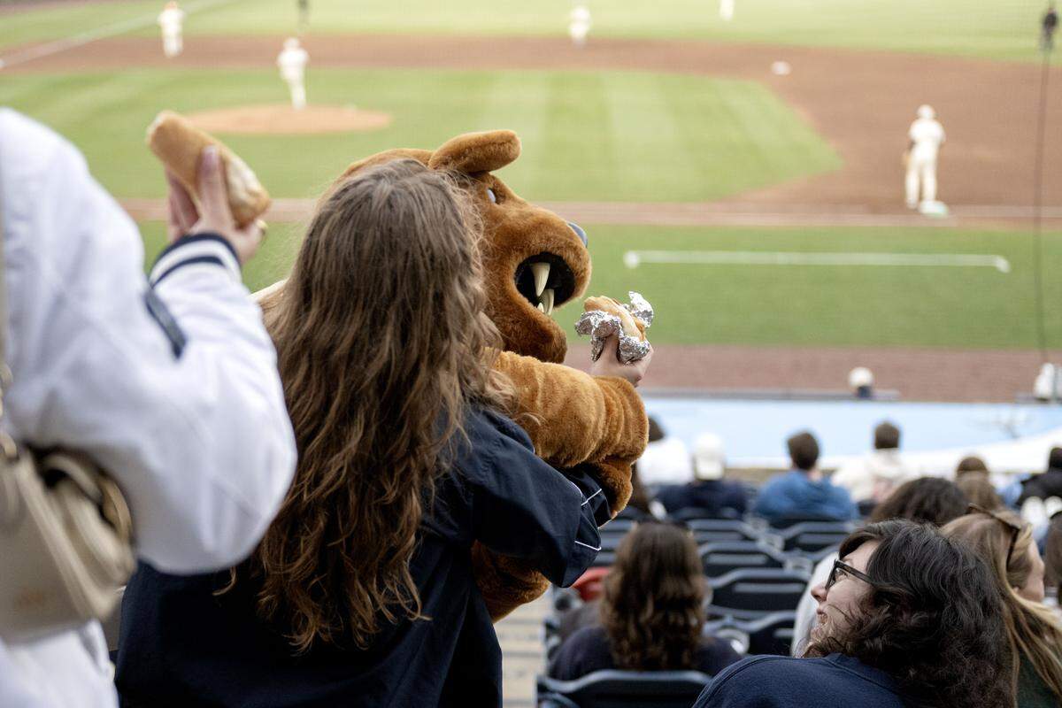 The Penn State Nittany Lion tries to take a bite of a fan’s hot dog during the first Dollar Dog Night of the season at Penn State baseball on Tuesday, March 24, 2026. 