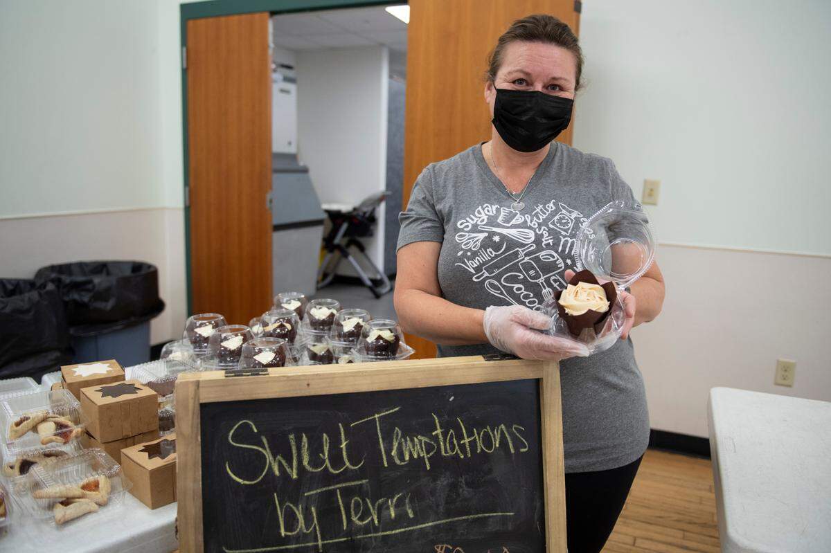 Terri Spahr, owner of Sweet Temptations by Terri, poses with a cupcake at the Boalsburg Farmers Market on Tuesday.