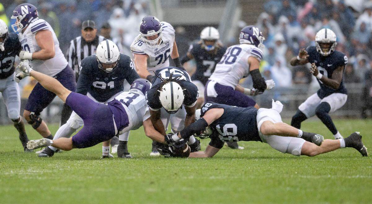 Northwestern’s Ryan Hilinksi and Penn State defensive ends Hakeem Beamon and Nick Tarburton all dive for the ball during the game on Saturday, Oct. 1, 2022.
