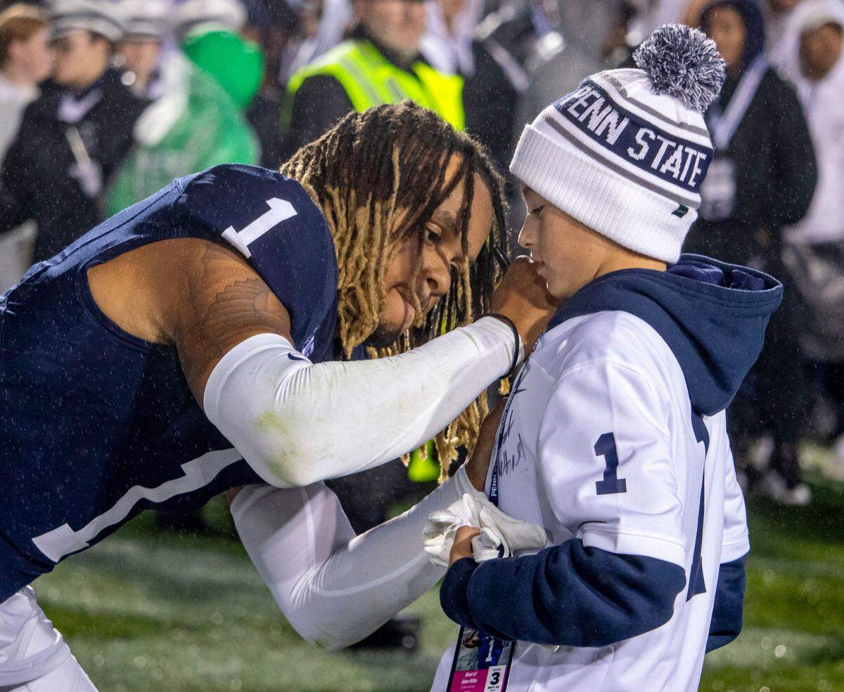 Penn State safety Jaylen Reed (1) signs a young fan’s jersey on the field after Penn State football’s game against Iowa on Saturday, Sept. 23, 2023, at Beaver Stadium in University Park, PA.