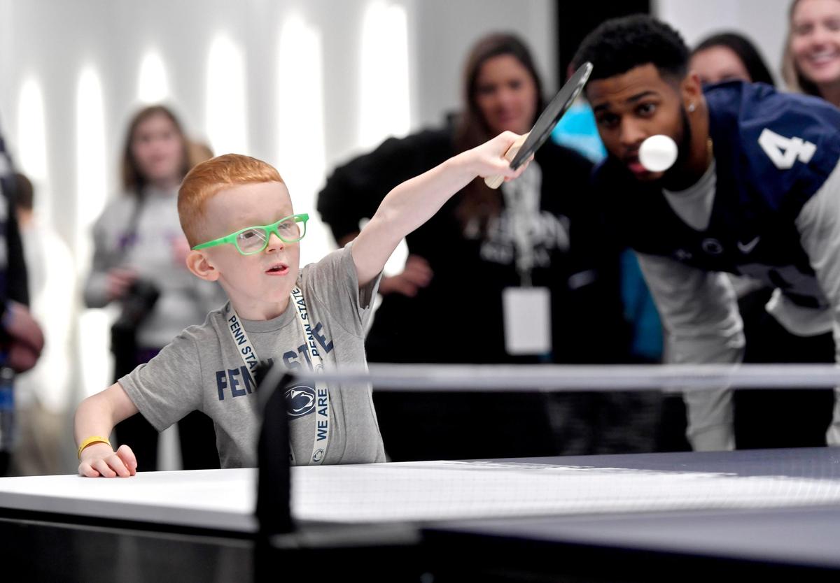 Owen Bonn, 6, returns the ball in an intense game of pingpong as his buddy Penn State running back Journey Brown watches in the Lasch Building on Saturday, Feb. 22, 2020.