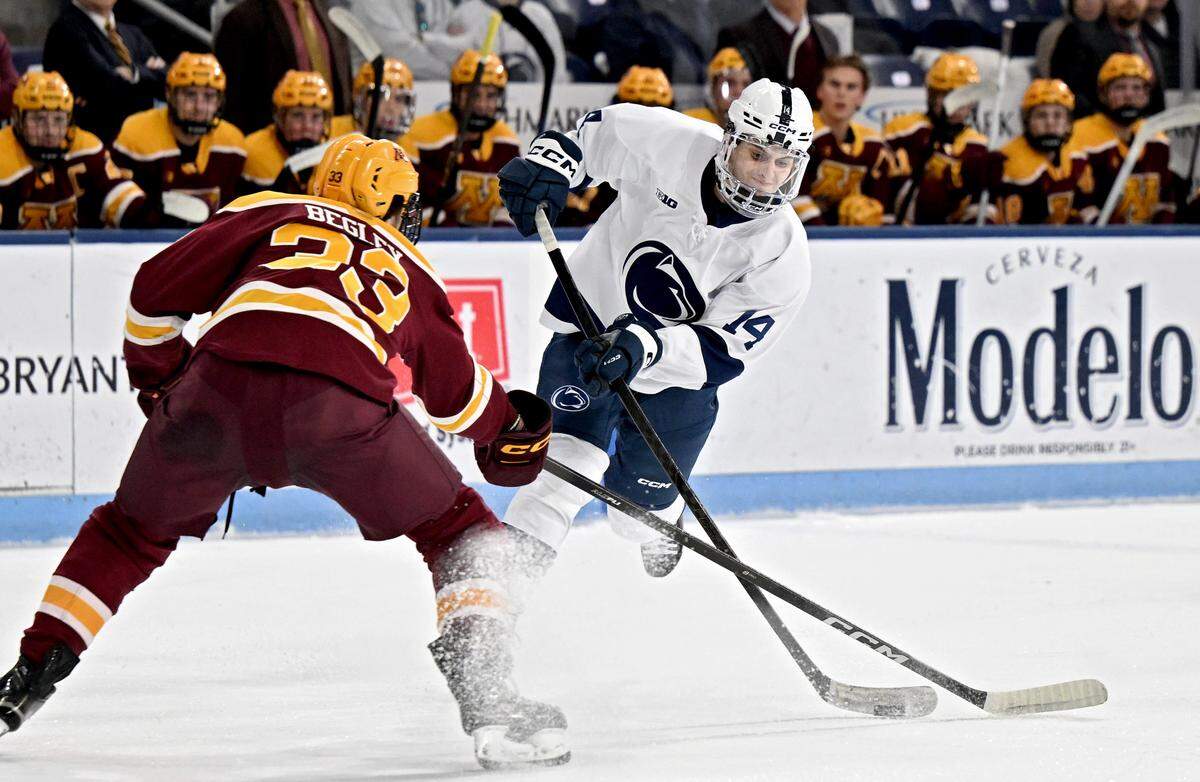 Penn State's Matt DiMarsico takes a shot around Minnesota defender Axel Begley during the game on Friday, Jan. 9, 2026 at Pegula Ice Arena. 