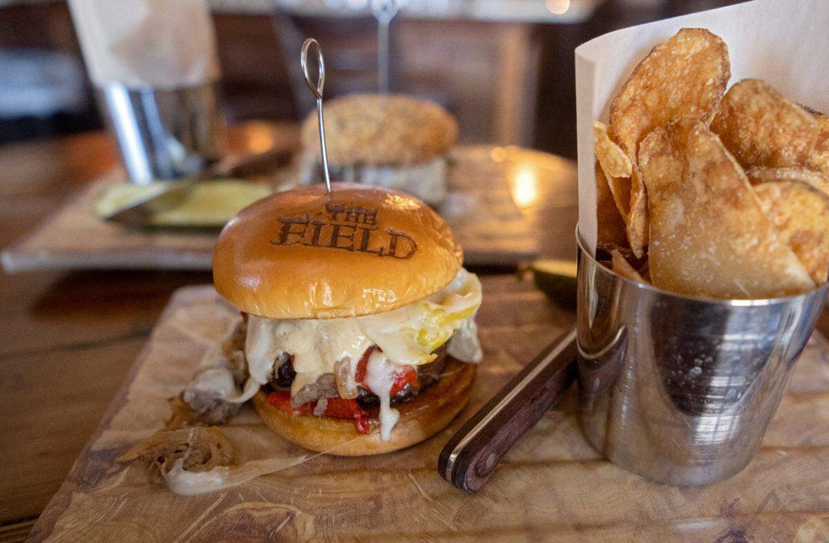The new Dambach-ery burger, a cheesesteak burger featuring rib eye, caramelized onion, peppers, provolone and roasted garlic parmesan mayo on brioche bun at The Field Burger & Tap on Wednesday, May 31, 2023.