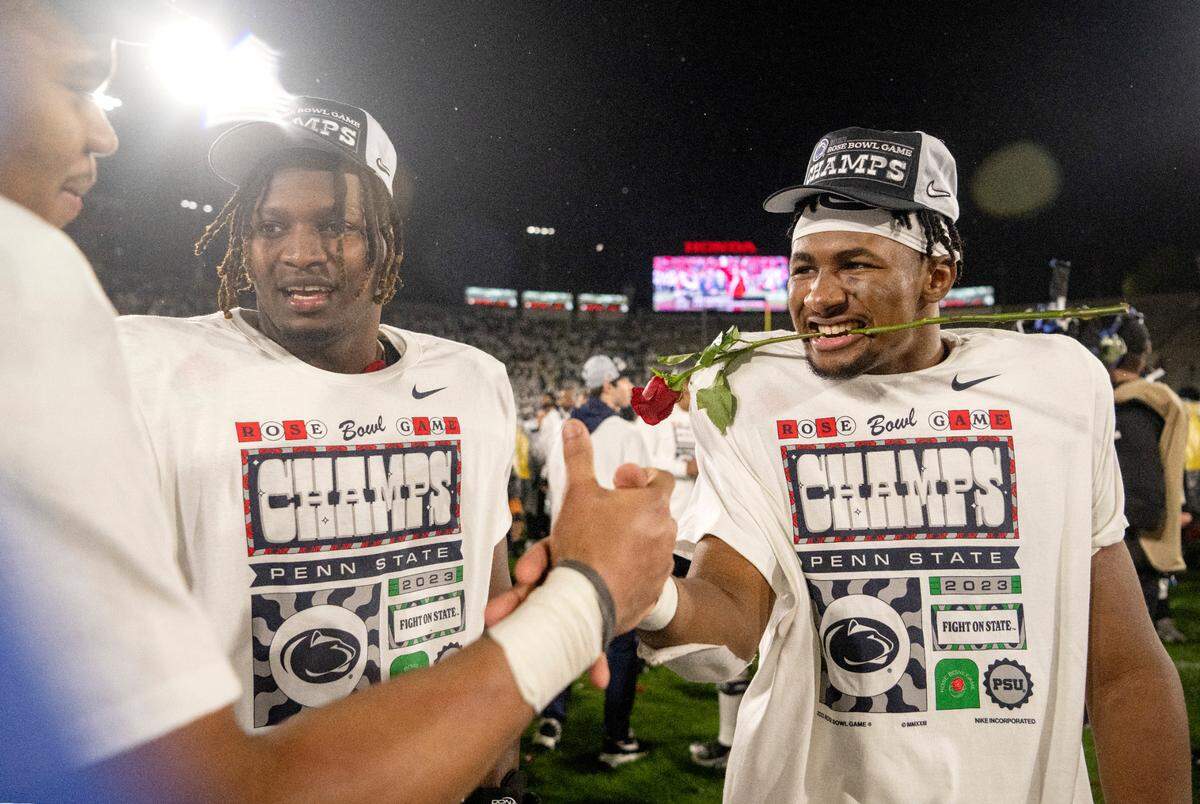Penn State running back Nick Singleton bites a rose as he and his teammates celebrate the 35-21 win over Utah in the Rose Bowl on Monday, Jan. 2, 2023.