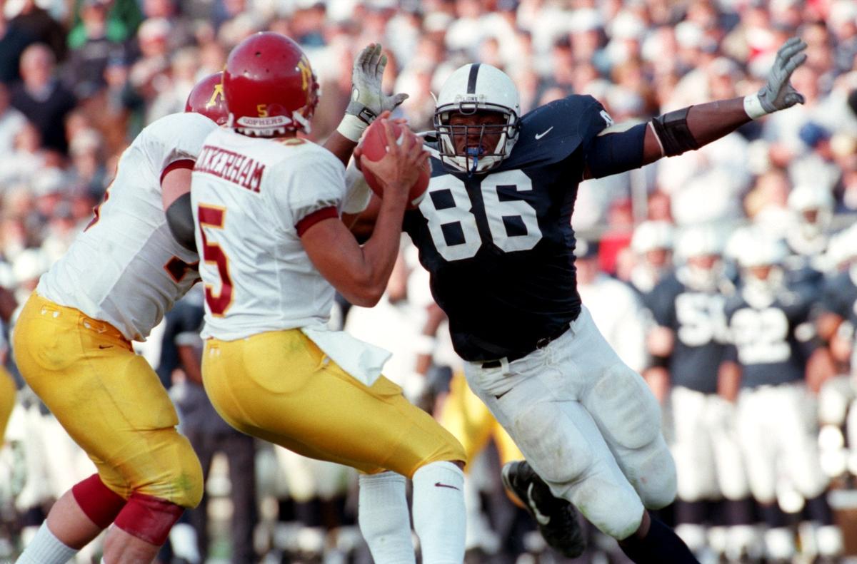 Penn State’s  Courtney Brown pressures  Minnesota quarterback Billy Cockerham in the fourth quarter of their game in 1999.