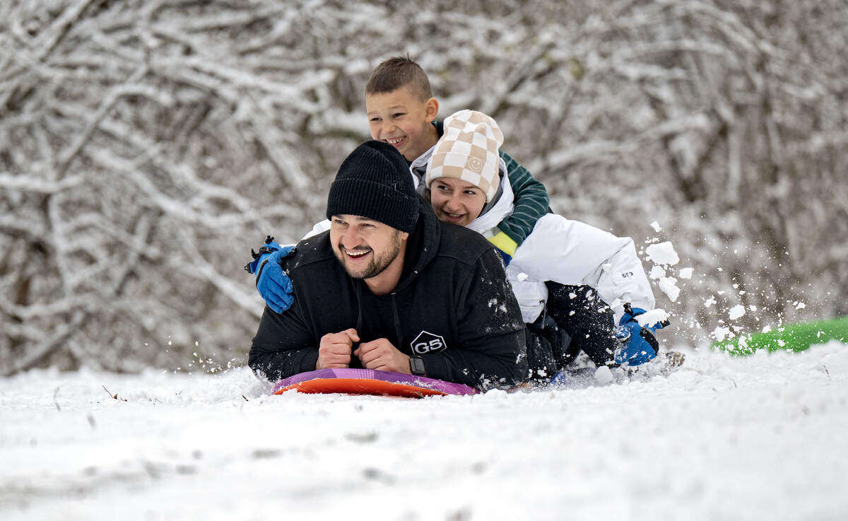 Eli Ace laughs as he sleds with two of his kids, Elsa and Joshua, at Slab Cabin Park on Tuesday, Dec. 2, 2025.