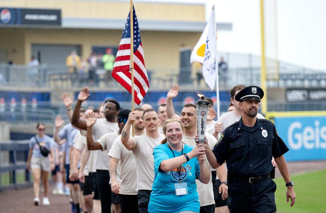 Three River Region athlete Nancy Grimm and Monroeville Police Department Officer Pierre DeFelice carry the flame of hope into the Medlar Field to light the cauldron for the Special Olympics PA Summer Games on Thursday, June 5, 2025.