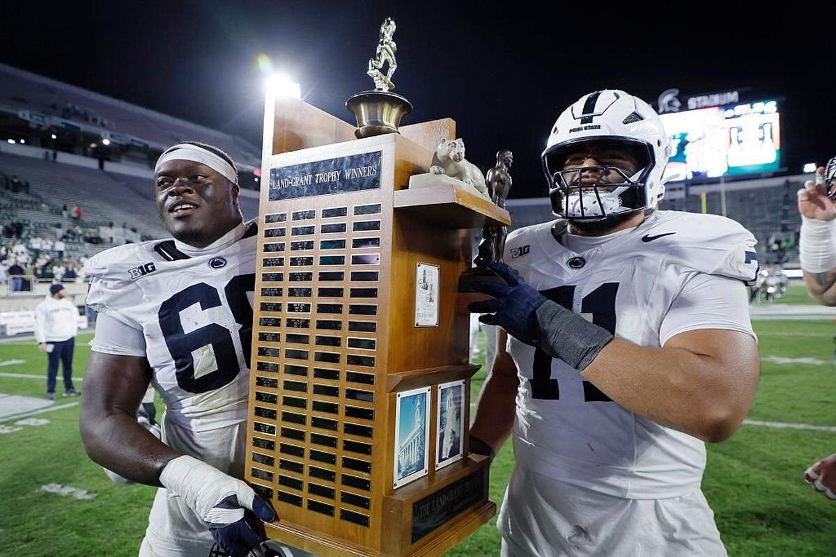EAST LANSING, MICHIGAN - NOVEMBER 15: Anthony Donkoh #68 and Olaivavega Ioane #71 of the Penn State Nittany Lions carry off the Land-Grant Trophy after defeating the Michigan State Spartans at Spartan Stadium on November 15, 2025 in East Lansing, Michigan. (Photo by Duane Burleson/Getty Images)