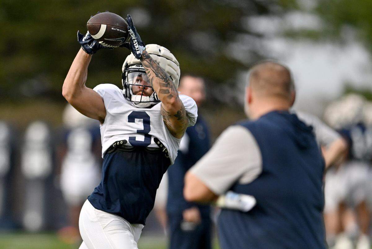 Penn State wide receiver Julian Fleming makes a catch as offensive coordinator Andy Kotelnicki watches during a spring practice on Tuesday, April 9, 2024.
