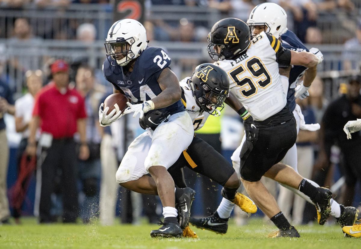 Penn State running back Miles Sanders runs from Appalachian State defenders during the Saturday, Sept. 1, 2018 game at Beaver Stadium.