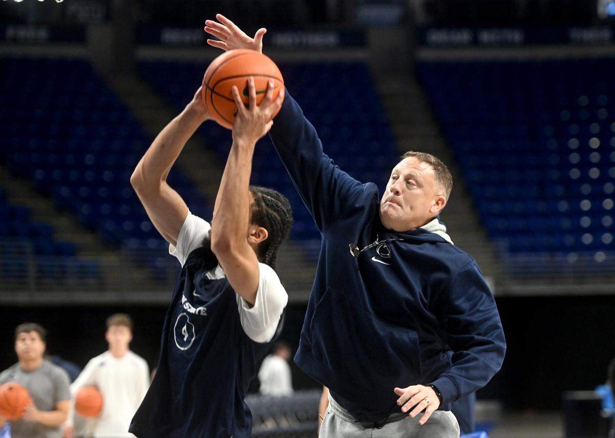 Penn State men’s basketball coach Mike Rhoades tries to block a shot by Freddie Dilione V during practice on Wednesday, Oct. 23, 2024.