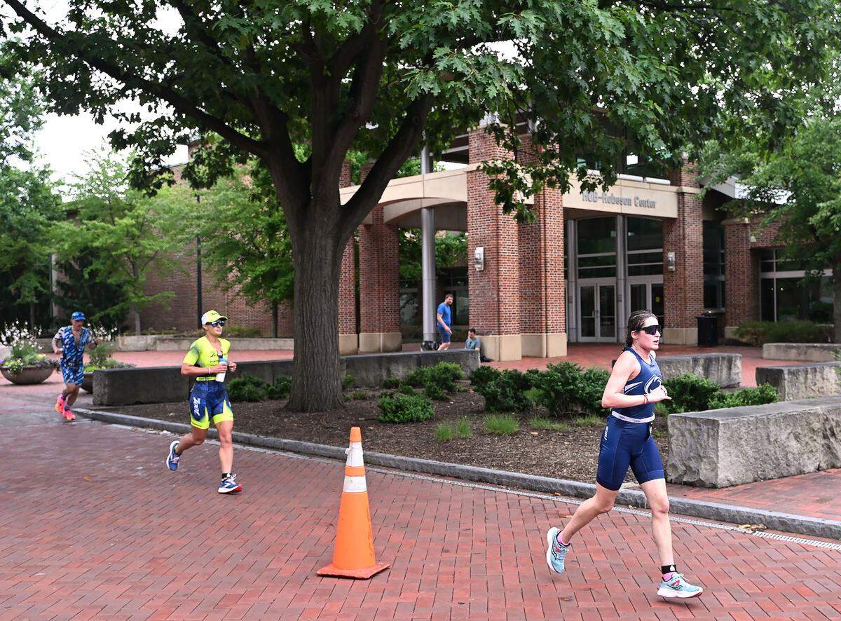 Participants in the Ironman 70.3 Pennsylvania Happy Valley run past the HUB-Robeson Center on the Penn State campus Sunday, July 2, 2023.