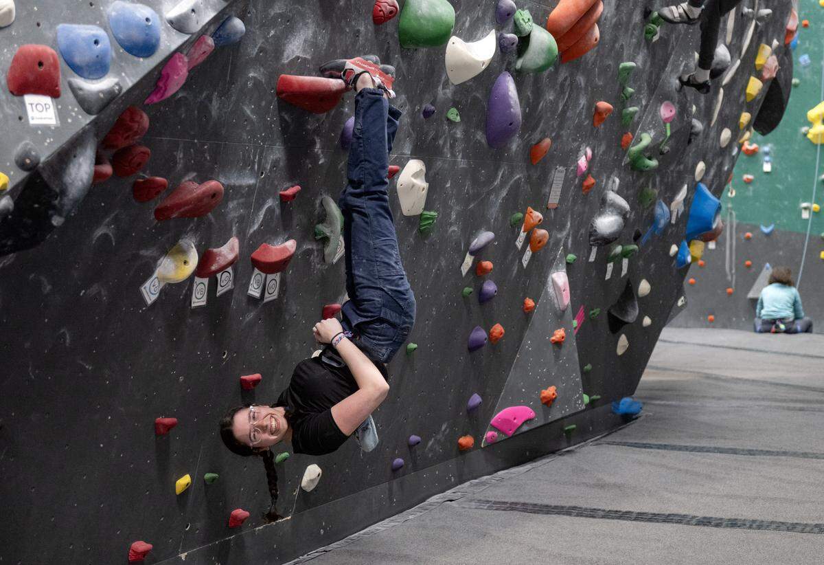 Shelly Ben Yehuda laughs with friends as she hangs upside  on the boulder wall at Climb Nittany on Thursday, May 14, 2026. 