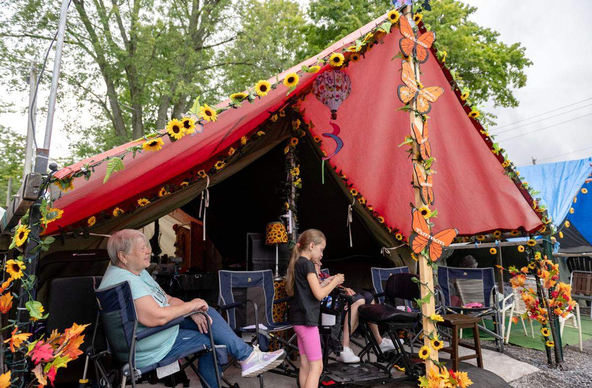 Patty Bird enjoys the porch of her family’s tent that was decorated with sunflowers and butterflies.