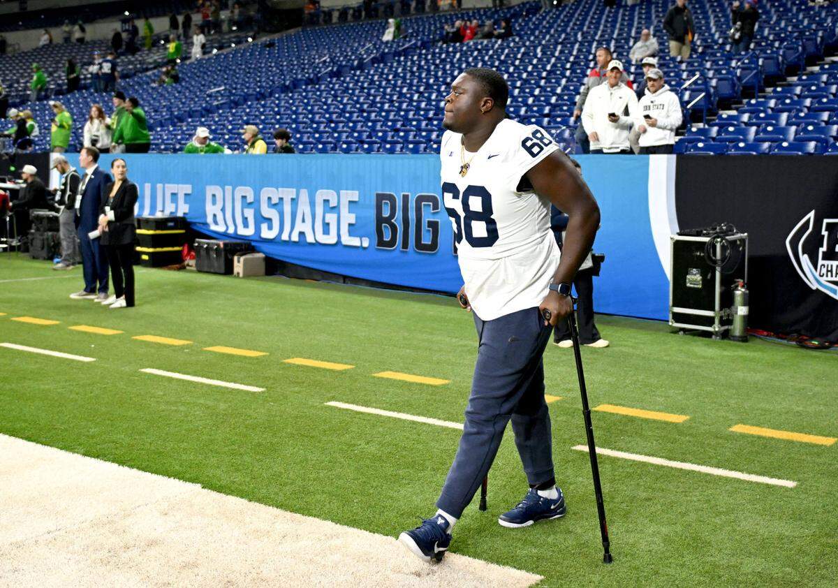 Penn State offensive lineman Anthony Donkoh walks onto the field with the crutches before the Big Ten Championship game at Lucas Oil Stadium on Saturday, Dec. 7, 2024.