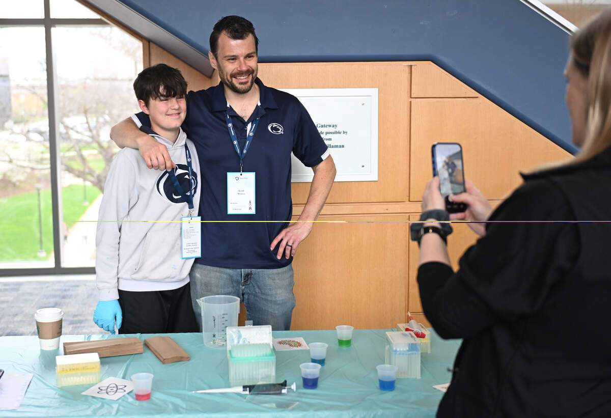 A family poses for a photo while making pipette art with the One Health Microbiome Center during Penn State’s Bring Our Children to Work Day on Monday, April 13, 2026.