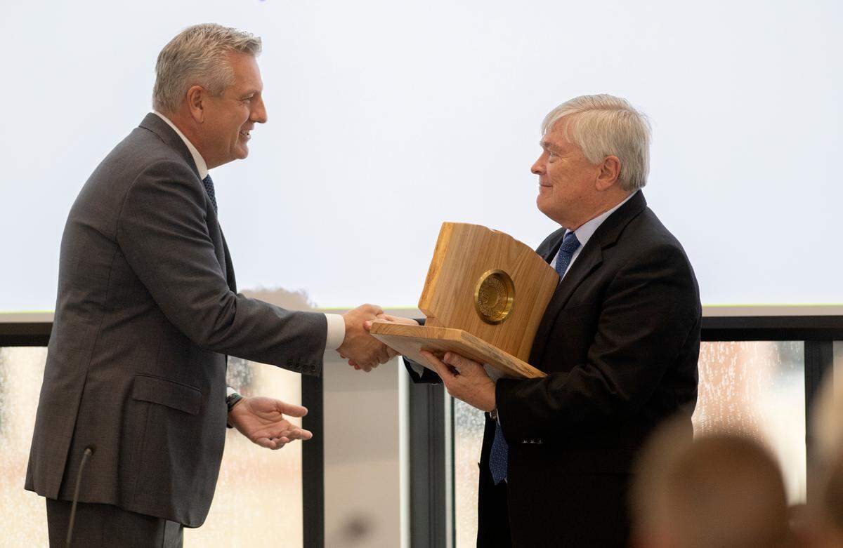 Penn State Board of Trustees chair Matt Schuyler presents Penn State president Eric Barron with a Penn State medal during the meeting on Friday in the Innovation Hub Building.