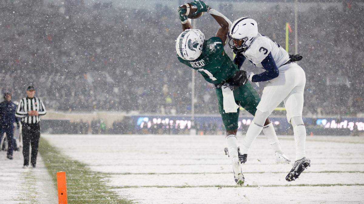 Michigan State’s Jayden Reed, left, catches a pass for a 20-yard touchdown on a fourth-and-15 against Penn State’s Johnny Dixon (3) during the fourth quarter of an NCAA college football game, Saturday, Nov. 27, 2021, in East Lansing, Mich. Michigan State won 30-27.