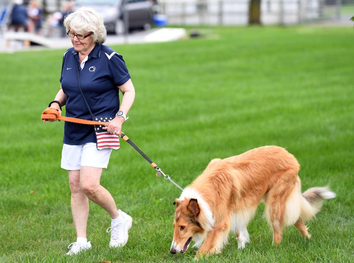 Dorean Whitman walks her dog, Luke, before the Penn State vs. Kent State game Saturday, Sept. 15, 2018 at Beaver Stadium.