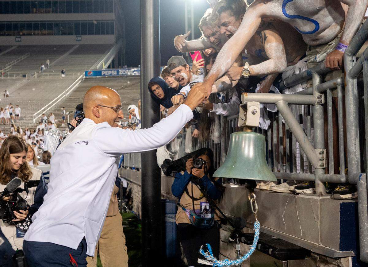 Penn State fans high-five coach James Franklin as he goes to ring the victory bell after the win over Indiana at Beaver Stadium.