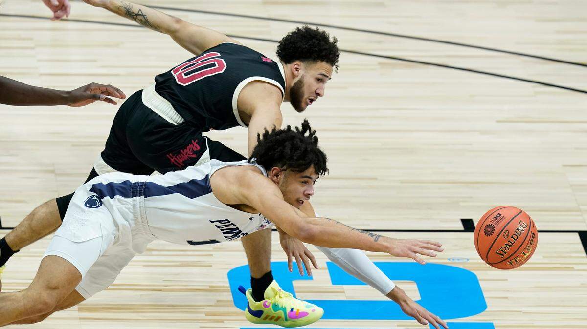 Nebraska’s Kobe Webster, top, and Penn State’s Seth Lundy dive for the ball during the first half of an NCAA college basketball game at the Big Ten men’s tournament, Wednesday, March 10, 2021, in Indianapolis.